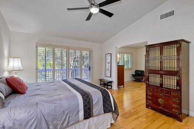 bedroom featuring light wood finished floors, visible vents, vaulted ceiling, a ceiling fan, and access to outside