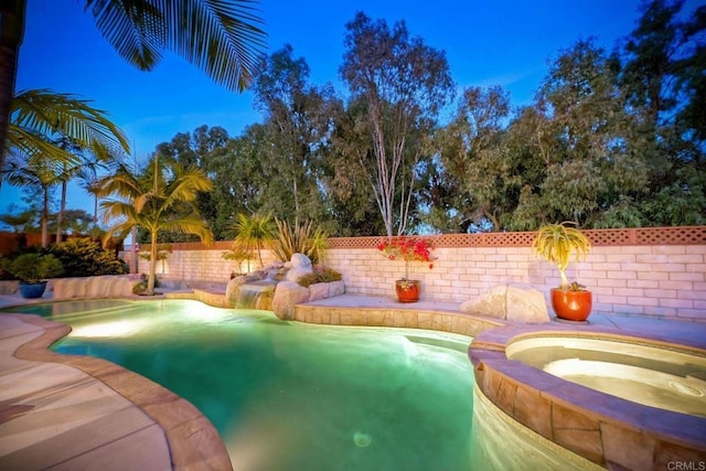 view of pool with a fenced backyard and a pool with connected hot tub