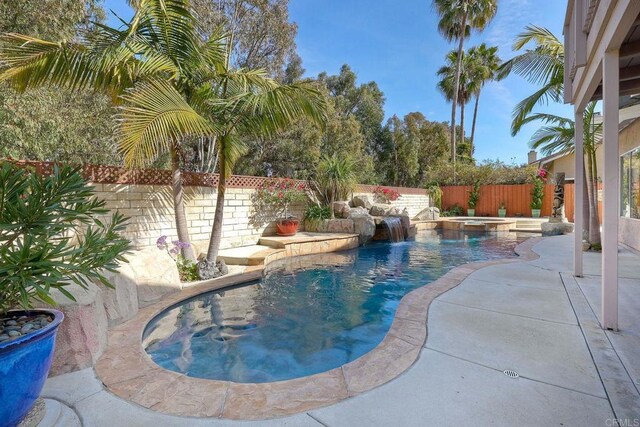 view of swimming pool featuring a pool with connected hot tub and a fenced backyard