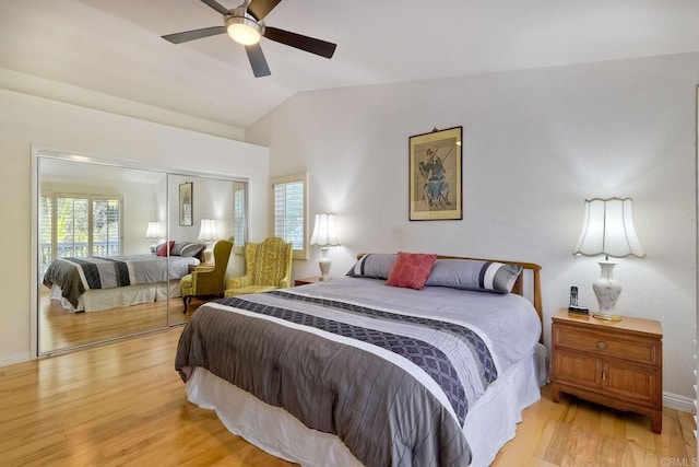 bedroom with a ceiling fan, baseboards, lofted ceiling, light wood-style floors, and a closet