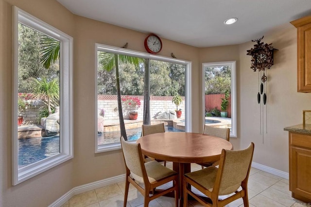 dining space with baseboards and light tile patterned flooring