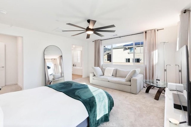 bedroom with light colored carpet, ceiling fan, and ensuite bathroom