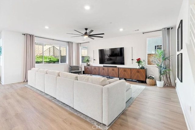 living area featuring a healthy amount of sunlight, light wood-type flooring, recessed lighting, and a ceiling fan