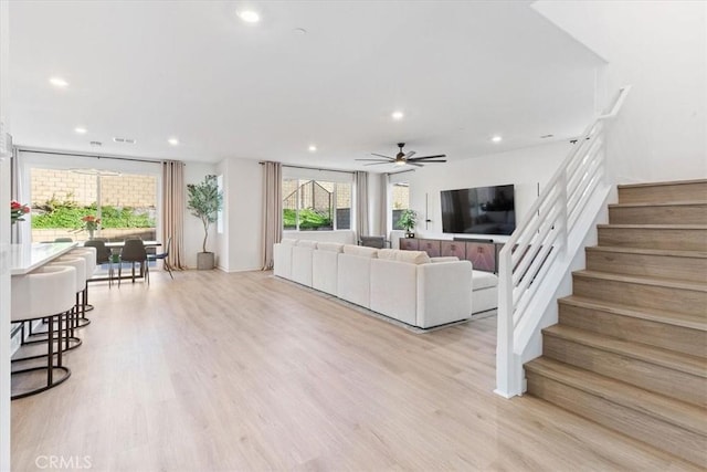 living area featuring a wealth of natural light, recessed lighting, stairway, and a ceiling fan