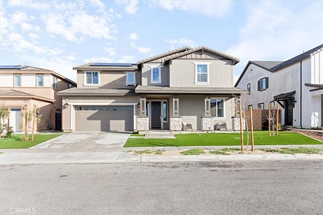 craftsman inspired home featuring roof mounted solar panels, driveway, stone siding, a front yard, and an attached garage
