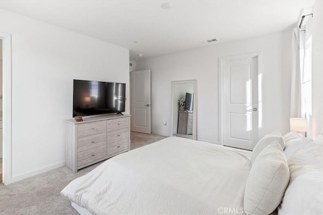 bedroom with baseboards, visible vents, and light carpet