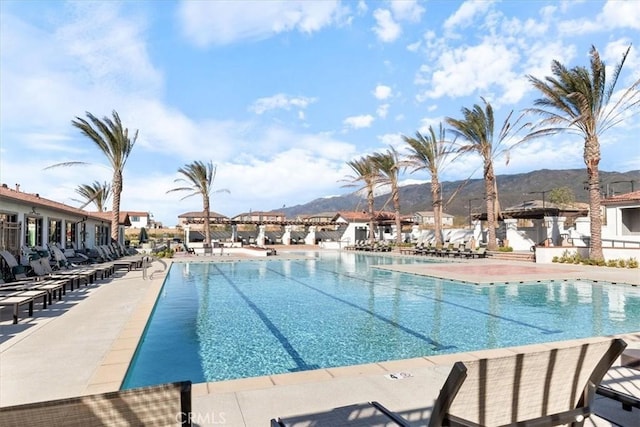 pool featuring a patio area, a mountain view, and a residential view
