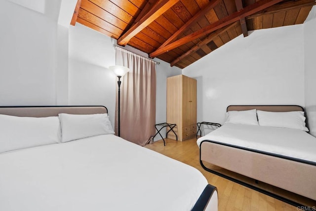 bedroom featuring lofted ceiling with beams, wood ceiling, and wood finished floors