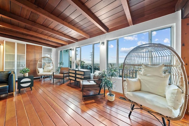 sunroom / solarium featuring a wealth of natural light, beam ceiling, and wooden ceiling