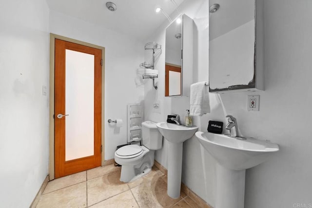 bathroom featuring tile patterned flooring, a sink, toilet, and baseboards