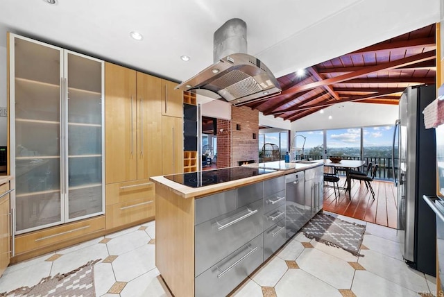 kitchen featuring vaulted ceiling with beams, light tile patterned floors, black electric stovetop, modern cabinets, and island exhaust hood