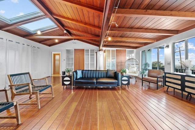 sunroom with vaulted ceiling with skylight, wooden ceiling, and rail lighting