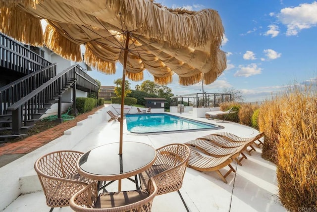 view of swimming pool with a patio area, stairs, and a fenced in pool