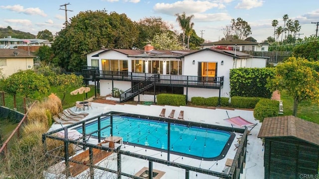 back of house with a fenced in pool, a patio area, fence, and stairs