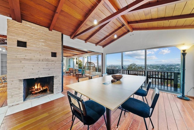 dining room with wood-type flooring, plenty of natural light, and lofted ceiling with beams