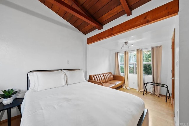 bedroom featuring vaulted ceiling with beams, light wood finished floors, and wood ceiling