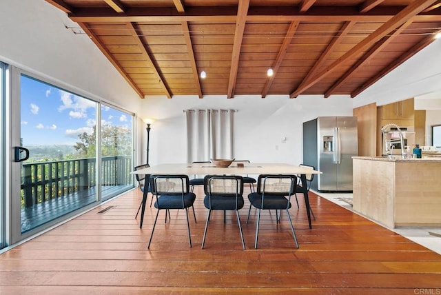 dining area featuring lofted ceiling with beams, hardwood / wood-style flooring, and wood ceiling