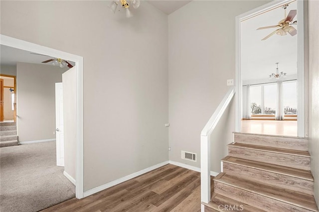 stairway featuring baseboards, ceiling fan, wood finished floors, and visible vents