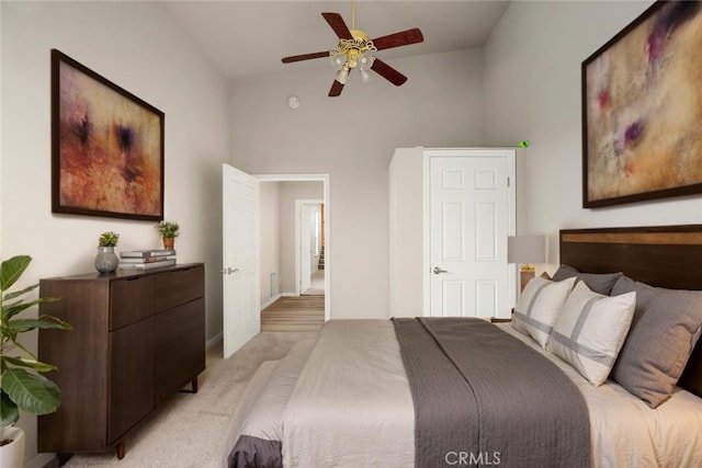 bedroom with light colored carpet, a ceiling fan, baseboards, and lofted ceiling