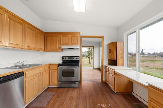 kitchen with a sink, light countertops, stainless steel appliances, and under cabinet range hood