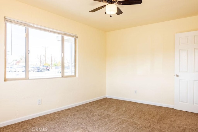 unfurnished room with ceiling fan and carpet