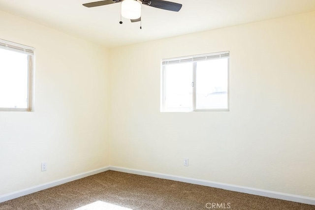 empty room featuring ceiling fan, plenty of natural light, and carpet