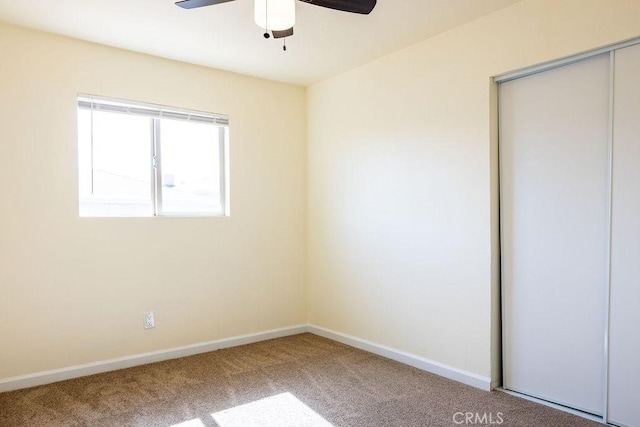 unfurnished bedroom featuring ceiling fan, a closet, and carpet