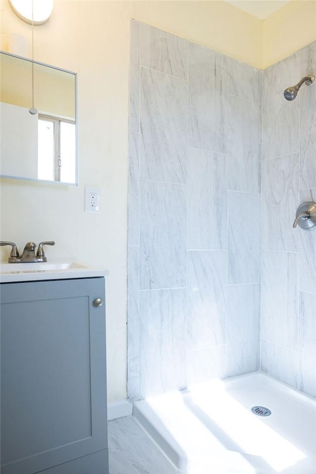 bathroom with vanity and a tile shower