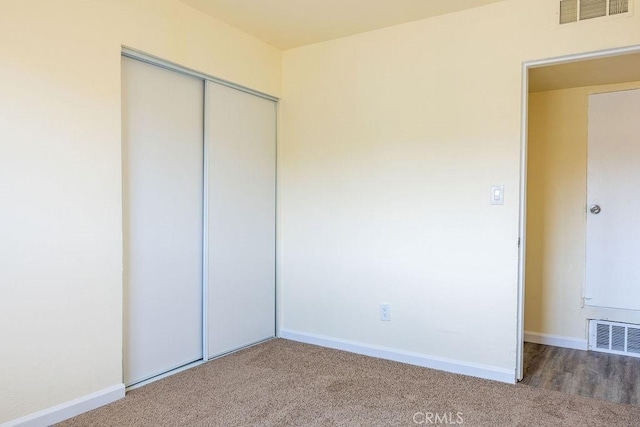 unfurnished bedroom with carpet floors and a closet