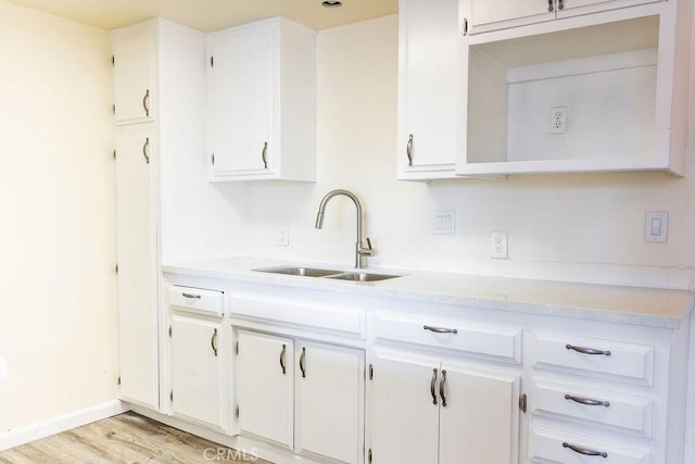 kitchen featuring white cabinetry, sink, and light hardwood / wood-style floors