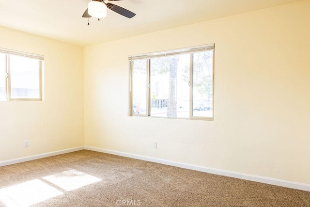 empty room with ceiling fan, plenty of natural light, and carpet floors