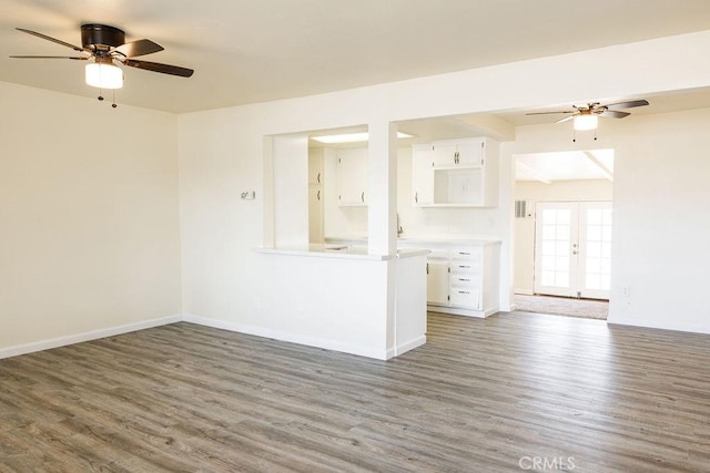 spare room with dark hardwood / wood-style floors, ceiling fan, and french doors