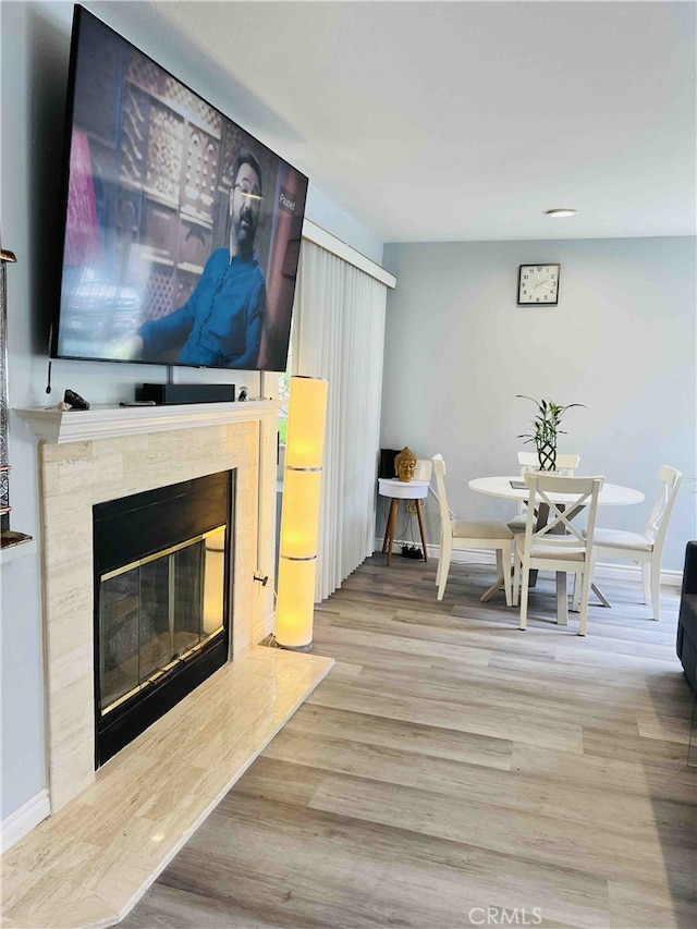 dining space featuring a high end fireplace and light hardwood / wood-style flooring