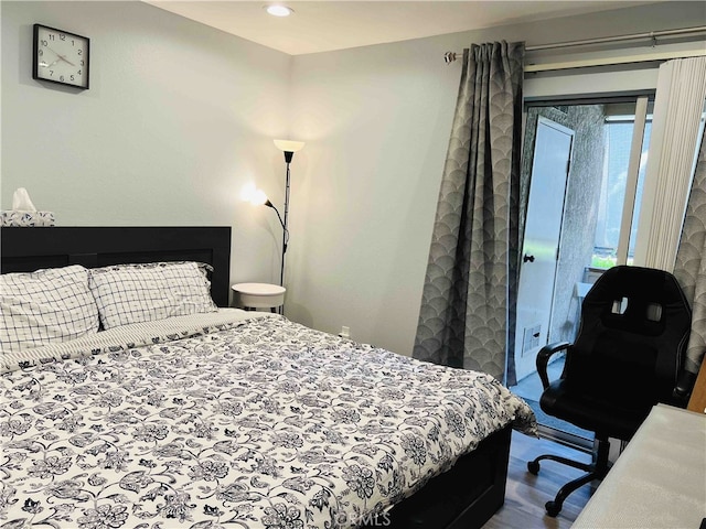 bedroom featuring wood-type flooring and access to outside