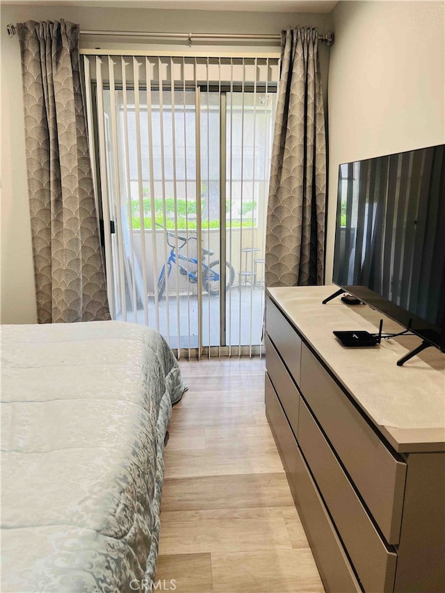 bedroom featuring access to exterior and light wood-type flooring