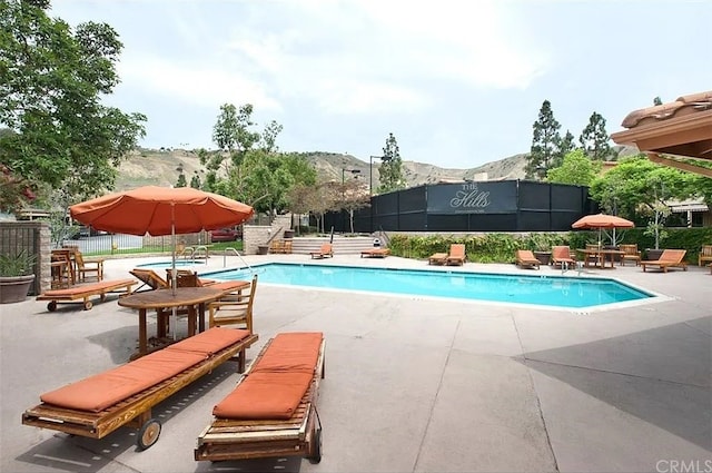 view of pool with a mountain view and a patio area