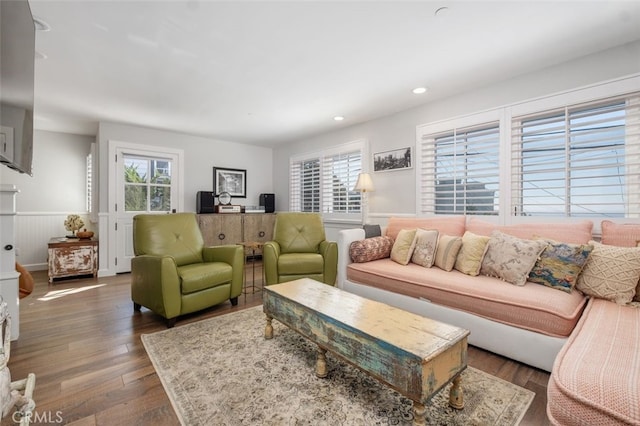 living area with a wainscoted wall, wood finished floors, and recessed lighting