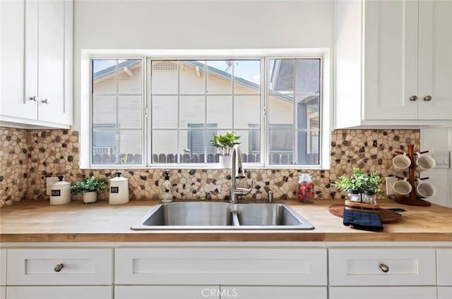 kitchen with white cabinetry, sink, and decorative backsplash