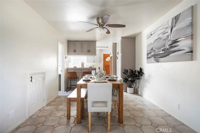 kitchen featuring gray cabinets, a kitchen breakfast bar, and ceiling fan