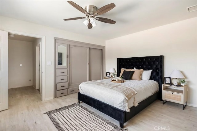 bedroom featuring ceiling fan, a closet, and light hardwood / wood-style flooring