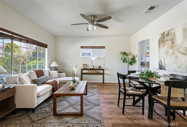 living room with dark wood-type flooring and ceiling fan