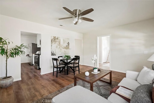 living room with ceiling fan and dark hardwood / wood-style flooring