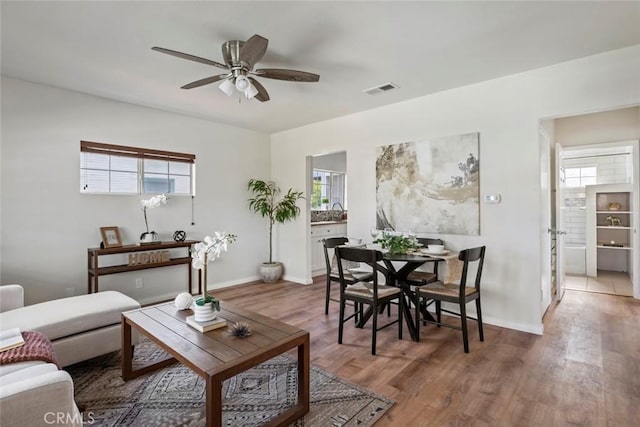 living room featuring hardwood / wood-style flooring, sink, and ceiling fan