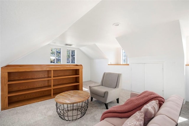 living area with carpet flooring, vaulted ceiling, and a wealth of natural light