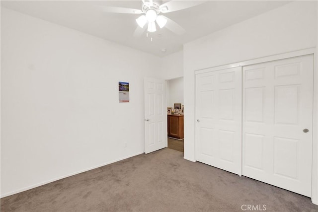 unfurnished bedroom featuring light colored carpet, ceiling fan, and a closet