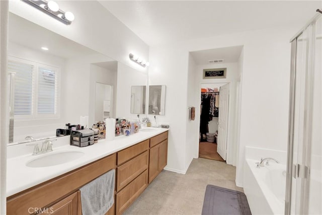 bathroom featuring vanity and a washtub