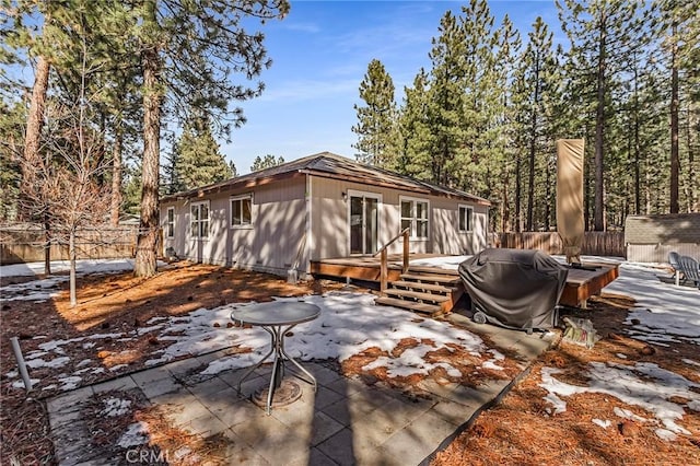 back of property with a patio area, an outbuilding, a deck, and fence