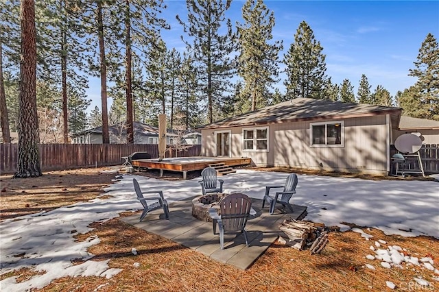 rear view of house featuring a patio area, an outdoor fire pit, and fence