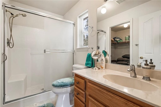 bathroom with visible vents, a shower stall, toilet, and vanity