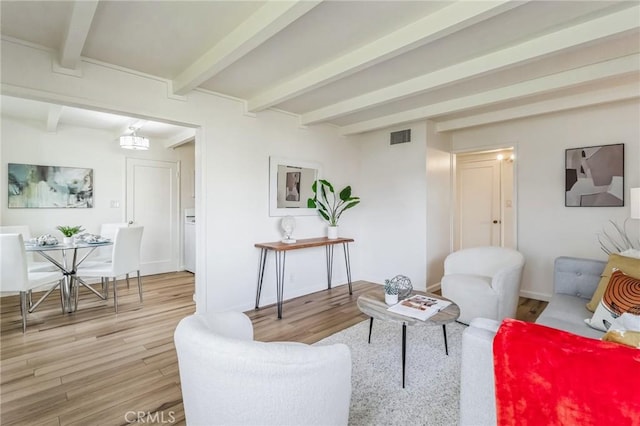 living room featuring beamed ceiling and light wood-type flooring